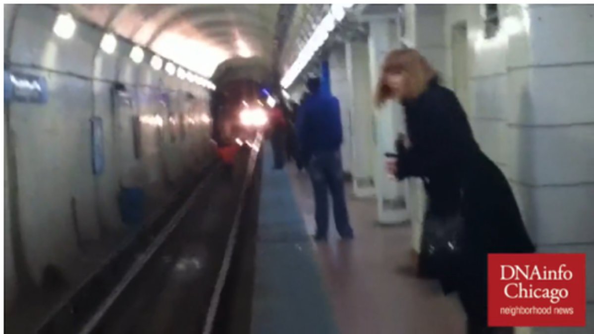 Här ser man mannen stå på spåret och vinka åt tåget